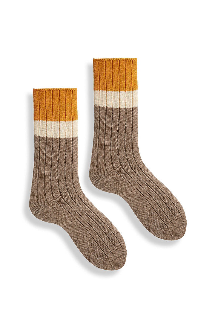 A pair of colorblock crew socks with mushroom, cream, and orange colors and snug ribbing.