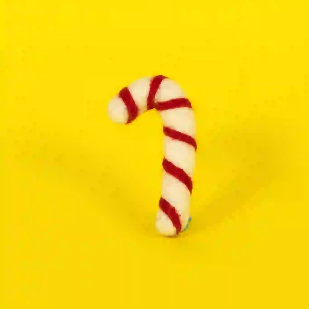 A candy cane-shaped cat toy made of lambswool with a red and white striped design, displayed on a yellow background.