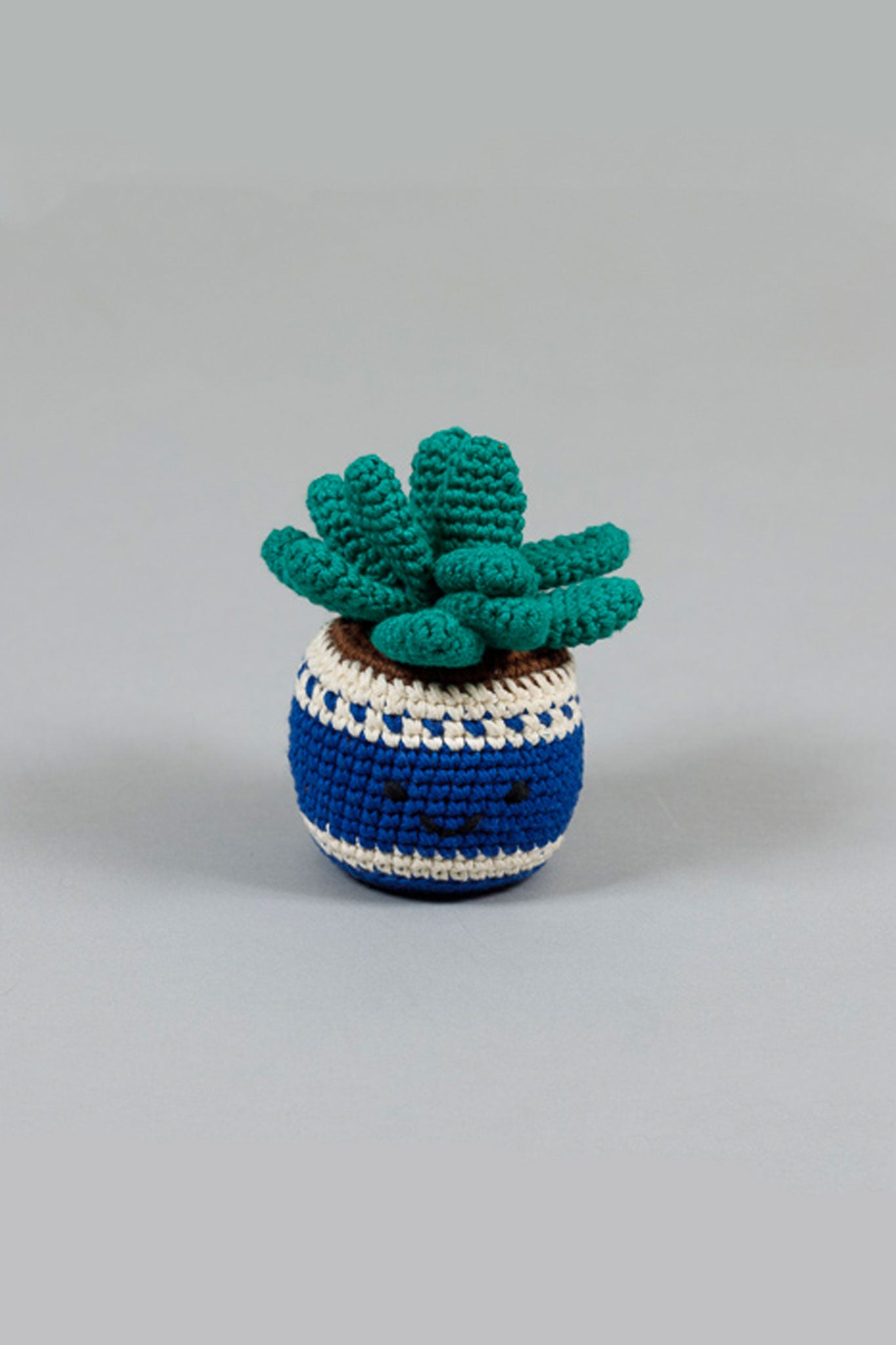 A crochet potted cactus dog toy with green leaves and a blue and white striped pot.