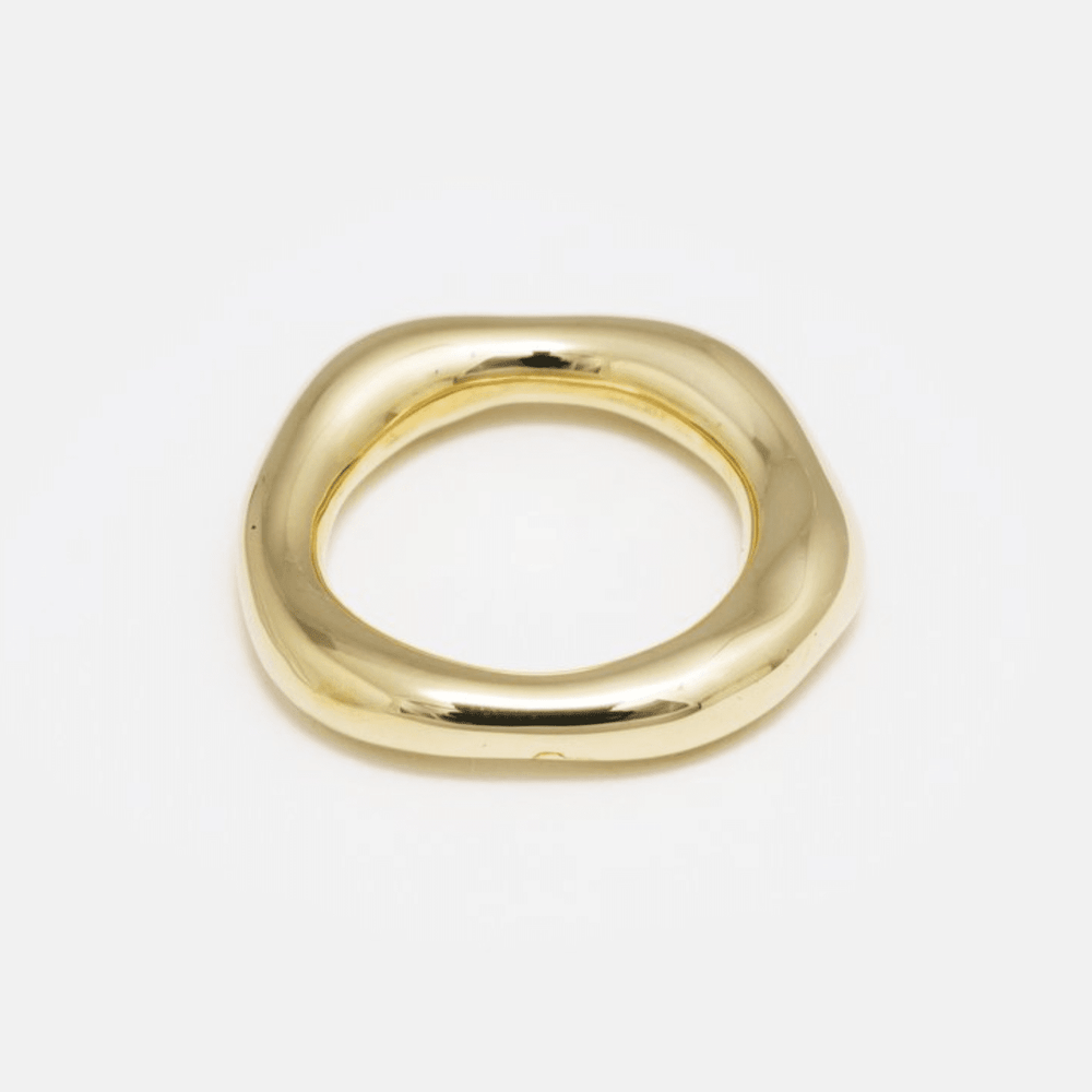A simple gold brass organic band ring on a white background.