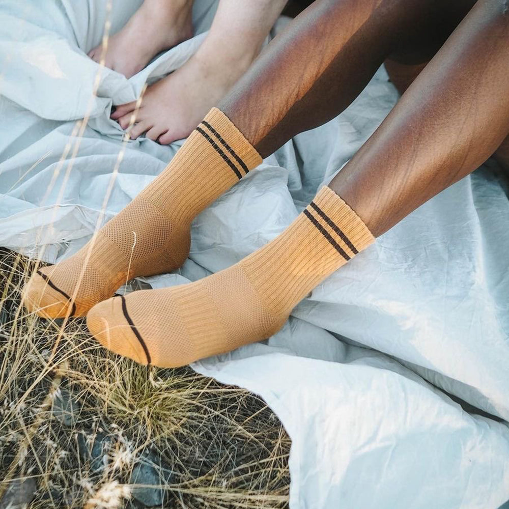 A person wearing yellow ribbed striped crew socks
