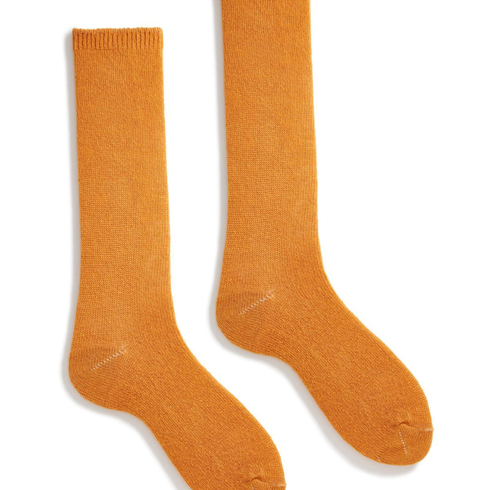 A pair of squash orange wool cashmere socks laid out flat.