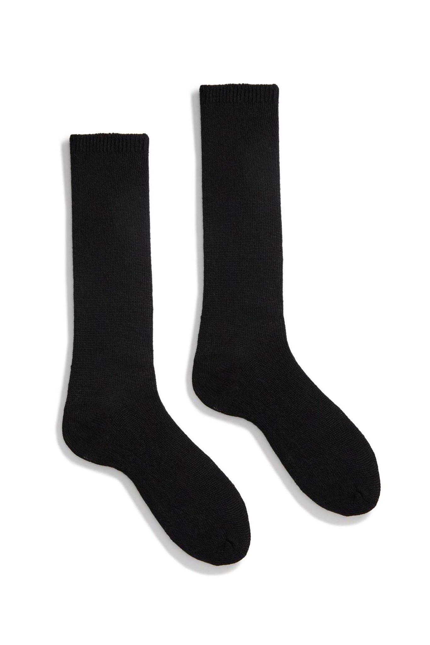 A pair of black cashmere socks against a white background.